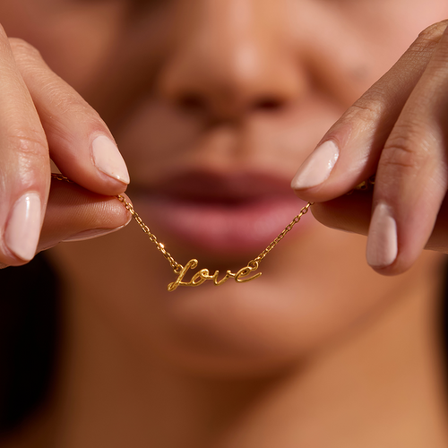 Close-up of a person holding the Adorned with Love Gold Necklace, showcasing its intricate details. This exquisite piece serves as a talisman of love and spirituality, ideal for meaningful manifestations.