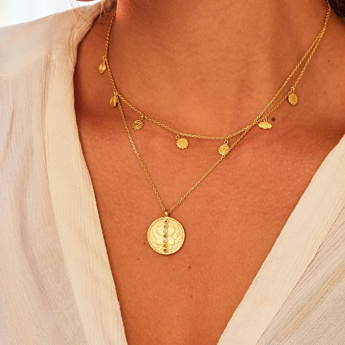 A close-up of the Aligned in Harmony Chakra Choker layered with another elegant necklace, beautifully highlighting its gold plates and chakra engravings. This spiritual jewelry piece is ideal for those seeking protection, energy balance, and inspiration in their meditation and yoga practices.