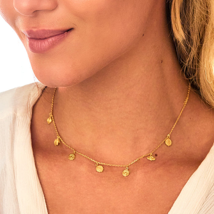 Model wearing the Aligned in Harmony Chakra Choker, emphasizing its radiant gold design and chakra symbols. This spiritual jewelry piece serves as a meaningful talisman for manifestation, connecting the sun, moon, and zodiac energies during meditation and yoga.