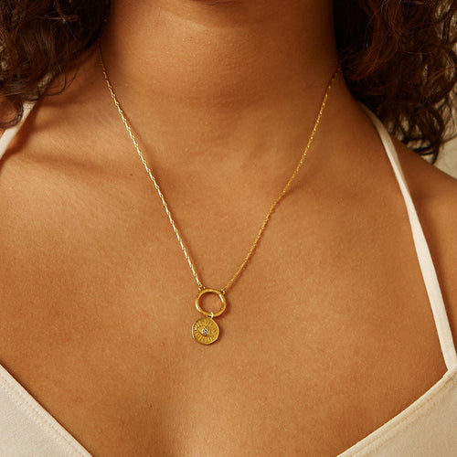 All Seeing Eye White Topaz Charm elegantly displayed on a delicate gold chain necklace worn by a model. This spiritual jewelry enhances meditation practices and acts as a protective charm, embodying the essence of sun and moon energies for meaningful manifestation in everyday life.