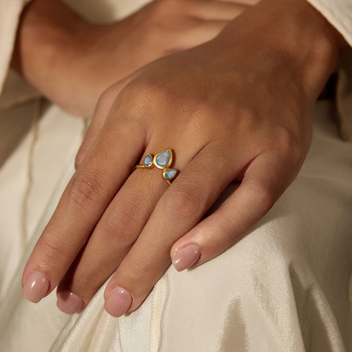 A hand adorned with the Awaken Intuition Labradorite Petal Ring, featuring enchanting labradorite stones set in 18kt gold plate. This piece embodies spiritual significance, making it a perfect choice for meditation, manifestation, and personal protection.
