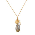 Gold cord necklace with labradorite teardrop pendant, small clear crystal charm, and gold lotus flower accent.