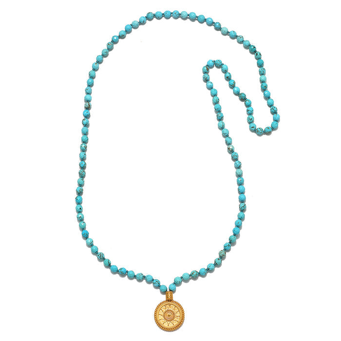 Beyond the Horizon Turquoise Mala featuring 108 turquoise beads, an 18kt gold plated medallion, and white topaz stars, perfect for meditation and spiritual jewelry. This mala serves as a talisman for manifestation and embodies the meanings of vitality and protection found in sun and moon symbolism.