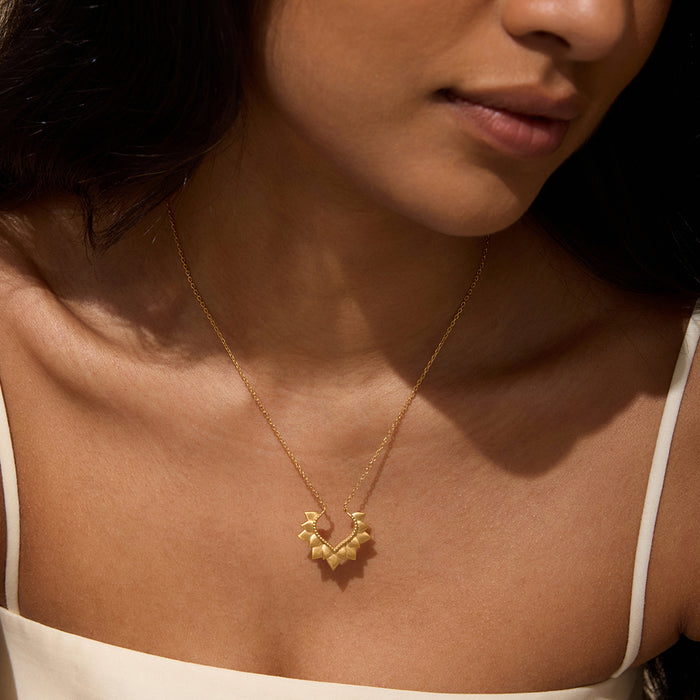 A close-up of a woman wearing the Blooming Love Lotus Petal Necklace, highlighting the delicate gold design that represents transformation and renewal. This spiritual jewelry embodies the essence of meaningful connection, ideal for those seeking protection while practicing yoga or meditation.