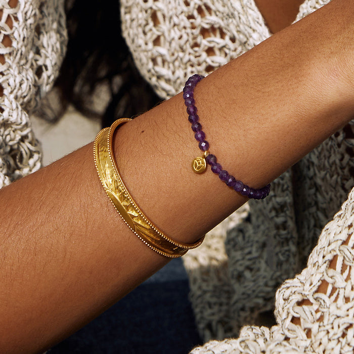 Close-up of the Breaking Dawn Sunrise Cuff bracelet paired with a purple beaded bracelet, representing meaningful spiritual jewelry. This cuff enhances the aesthetics of your talisman collection and promotes a sense of vitality and charm during yoga and meditation practices.