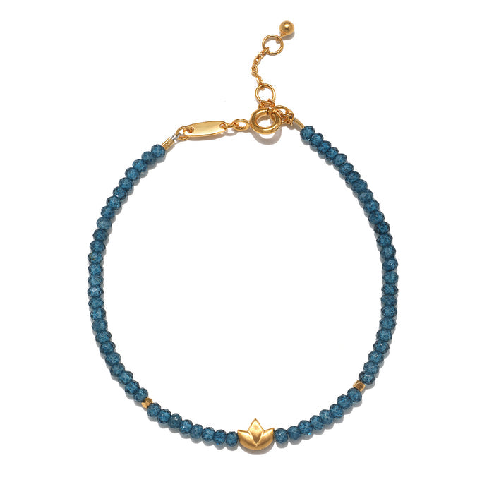 Blue beaded bracelet with gold-tone lotus charm and adjustable clasp.