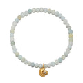 Stretch bracelet with pale aquamarine and cream beads, gold moon and sun charm with rhinestone accent.