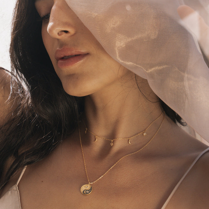 Model in soft natural light wearing the Celestial Balance Yin Yang White Topaz Necklace, symbolizing the unity of sun and moon. A meaningful talisman for spiritual seekers, perfect for enhancing meditation practices and personal manifestation.