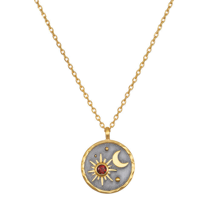 Celestial Birthstone Necklace - January featuring a pendant with a sun and moon design in 18kt gold plate on a gunmetal background, accented with a red garnet, symbolizing friendship and love, perfect for spiritual jewelry and meditation.