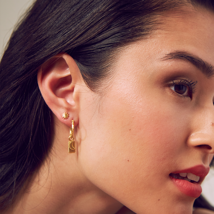 Profile view of a model wearing the Celestial Light Moon and Sun Stud Earrings alongside other stylish jewelry; the perfect addition for those seeking spiritual significance and manifestation in their accessories.