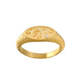 Gold signet ring with celestial engravings on oval face and small diamond accent.