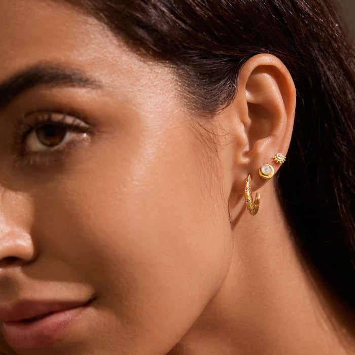 Close-up of a woman wearing Cradled in Light Moonstone Earrings, showcasing the 18kt gold plated crescent moon design and luminous moonstone, a perfect piece of spiritual jewelry for meditation and protection, symbolizing the sun and moon, ideal for yoga enthusiasts seeking meaningful manifestation.