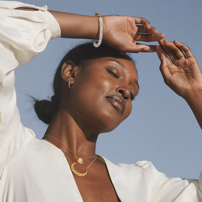Model wearing the Cradled in Light Moonstone Necklace, showcasing its elegance alongside other spiritual jewelry, ideal for yoga and meditation practices, representing protection, meaningful connections, and the essence of zodiac energies.