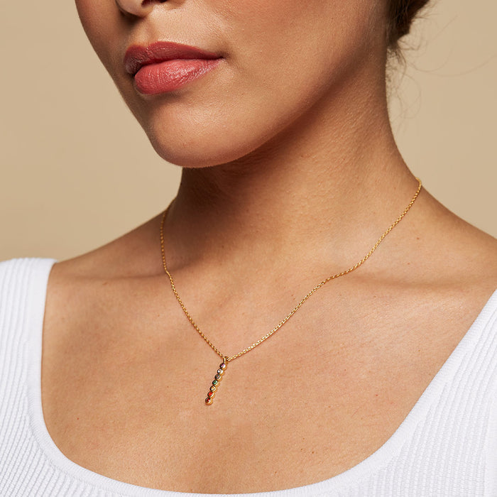 Model displaying the Divine Alignment Gemstone Chakra Necklace, highlighting its stunning vertical gemstone arrangement. This piece of spiritual jewelry makes an excellent meditation gift and reflects the essence of mantra and yoga. With its meaningful and symbolic design, it promotes manifestation and protective energies, serving as a significant amulet imbued with sacred vibes and zodiac meanings.