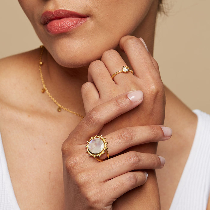 A model showcasing the Drift Into Daydreams Moonstone Ring alongside a delicate ring on her hand, embodying elegance and spiritual essence. This combination emphasizes the significance of spiritual jewelry in daily life, reflecting themes of yoga, meaningful connections, and the power of manifestation in balance with the universe.
