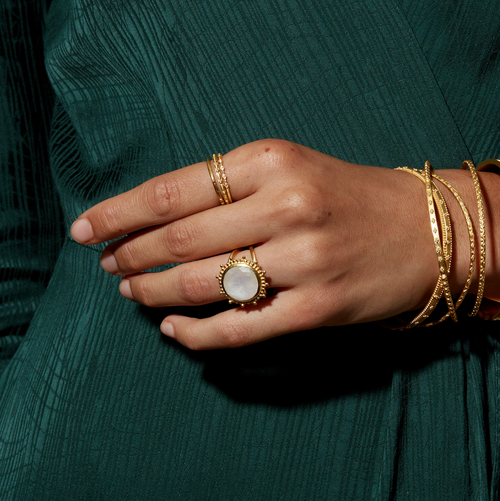 A hand adorned with the Drift Into Daydreams Moonstone Ring, showcasing the intricate beaded starburst design, perfect for those seeking spiritual jewelry, meditation, and meaningful manifestations.