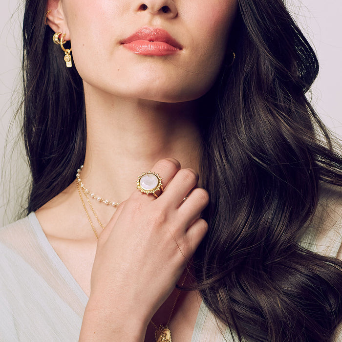 A woman wearing the Drift Into Daydreams Moonstone Ring, complemented by elegant necklaces and earrings, a beautiful representation of spiritual jewelry connected to the moon and its meaning.