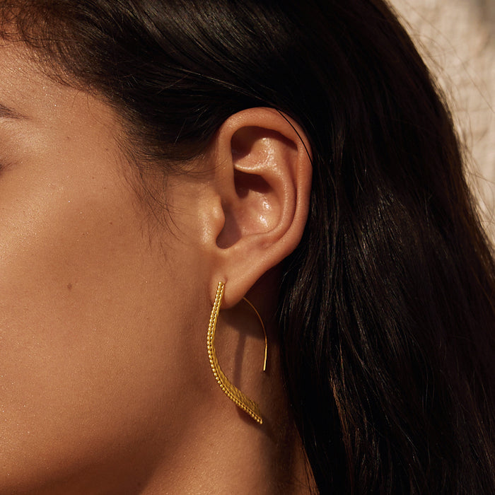 Embody Grace Lotus Petal Earrings showcased on a model, highlighting their elegant design and 18kt gold plating. These earrings serve as a beautiful talisman, embodying strength and renewal, perfect for meditation and yoga practices. The statement piece adds meaningful charm and protection to your spiritual jewelry collection.