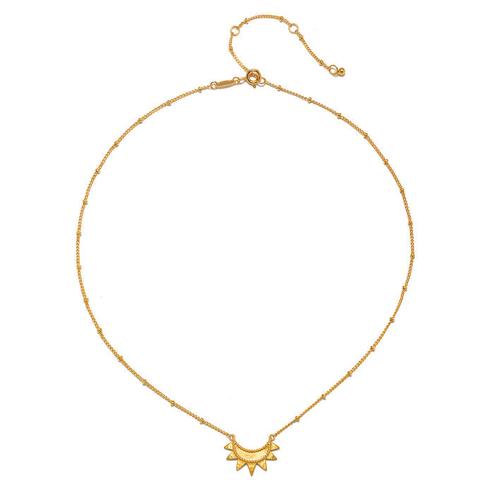Close-up view of the Emergence Gold Sunburst Necklace featuring a delicate sunburst pendant, a stunning piece that embodies the meaning of the sun in zodiac spirituality and serves as a lovely charm for yoga and meditation.