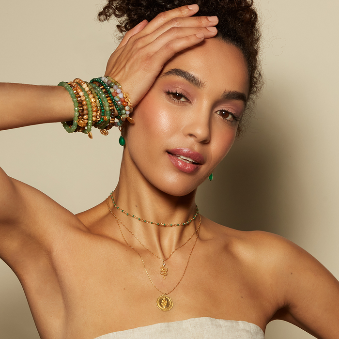 Eternal Energy Snake Coin Necklace worn by a model, paired with colorful bracelets, illustrating its meaningful role in personal style and spirituality. A lovely choice for those who appreciate talismans and sun, moon themes in their jewelry collection.