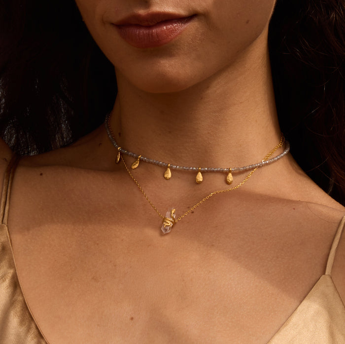 A beautiful display of layered necklaces, including the Eternal Spirit Clear Quartz Snake Necklace, perfect for yoga and spiritual practices, symbolizing the sun, moon, and the essence of meaningful meditation.
