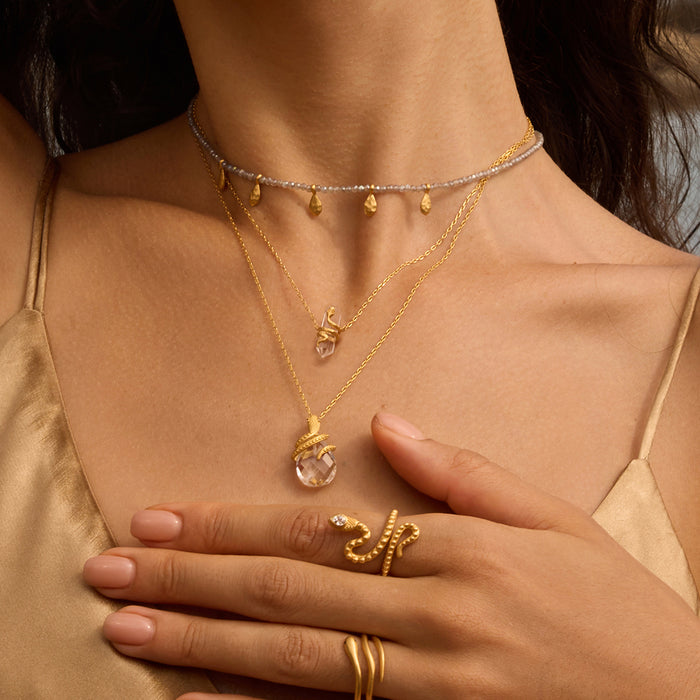 Close-up of the Eternal Spirit Clear Quartz Snake Necklace featured with other jewelry, symbolizing spiritual protection and the transformative meaning of the snake, ideal for those on a yoga or meditation journey.