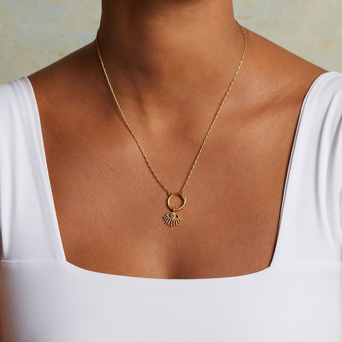 A model wearing an Evil Eye Labradorite Charm necklace, showcasing its elegant design that blends spiritual jewelry with style. This talisman represents protection and is perfect for yoga and meditation practices.