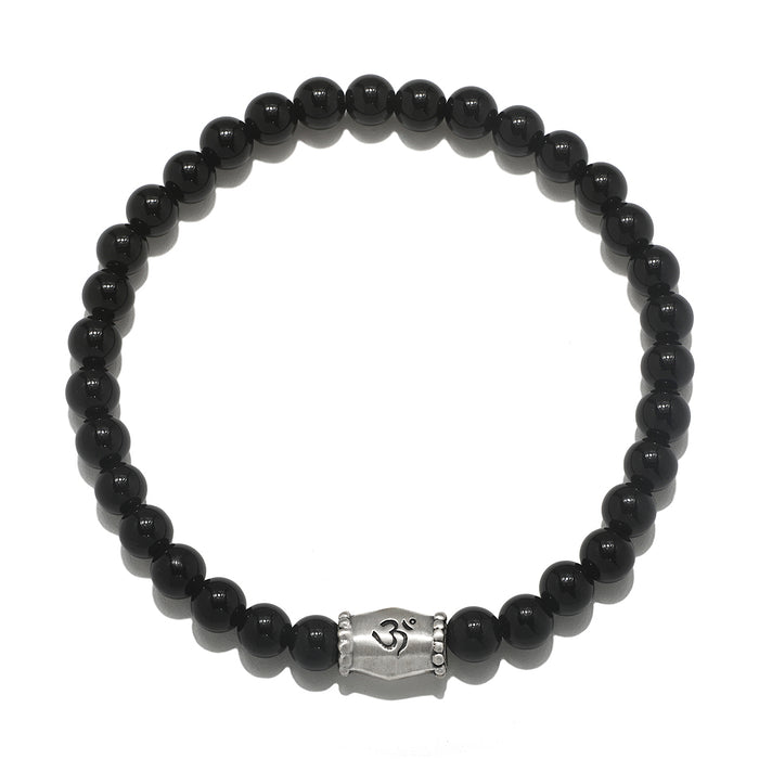 Extended Journey Men's Black Onyx Bracelet featuring a silver 'om' charm, representing spiritual jewelry that enhances meditation and serves as a meaningful talisman. This bracelet is perfect for those seeking protection and harmony in their yoga practice and aligns with the energies of the sun and moon, making it a beautiful manifestation charm.