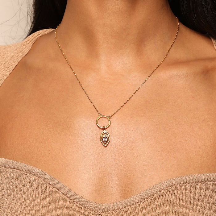 A model wearing the Feather White Topaz Charm on a delicate gold necklace, showcasing the charm's elegance and connection to spiritual meaning, perfect for yoga, talismans, and personal expression.