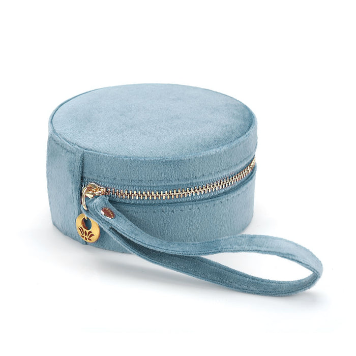 Exterior view of the For the Journey Travel Jewelry Case in soft blue velvet with a golden zipper and wrist loop. A stylish accessory for anyone who cherishes their spiritual jewelry and seeks to carry their meaningful pieces, such as zodiac symbols and malas, on their journey.