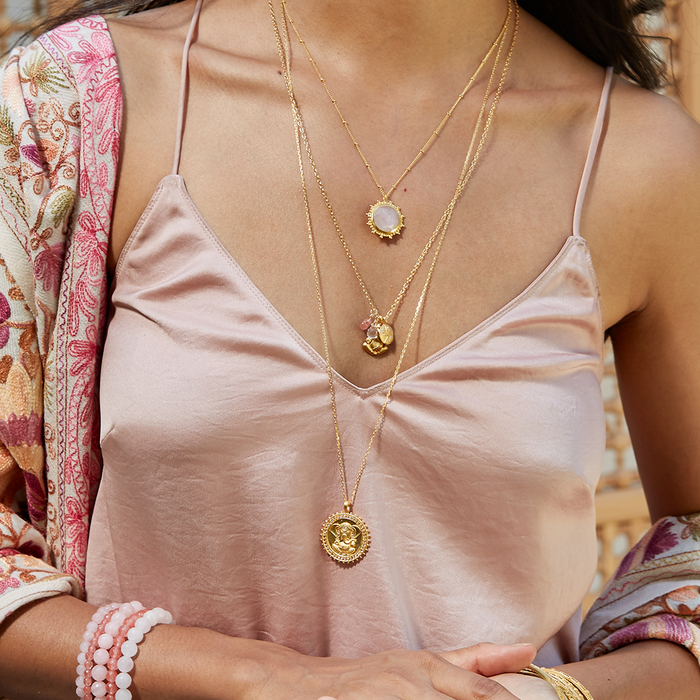 Close-up of a model wearing the Ganesha Hindu God, Path to Success Necklace along with other spiritual jewelry. This beautiful combination signifies spirituality, meditation, and the meaningful essence of talismans in yoga practices, promoting protection and manifestation under the influence of the sun and moon.