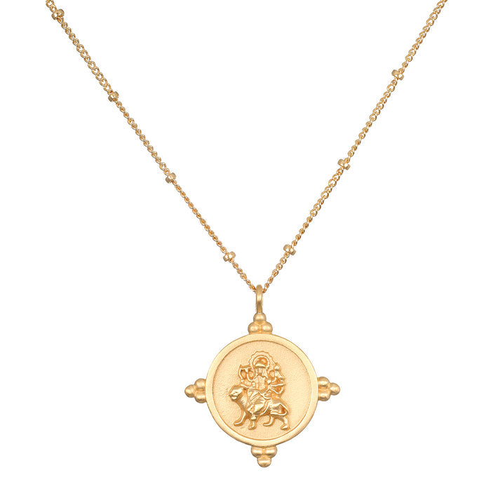 Gold-toned necklace with beaded chain and circular pendant featuring embossed deity figure with decorative corner details.