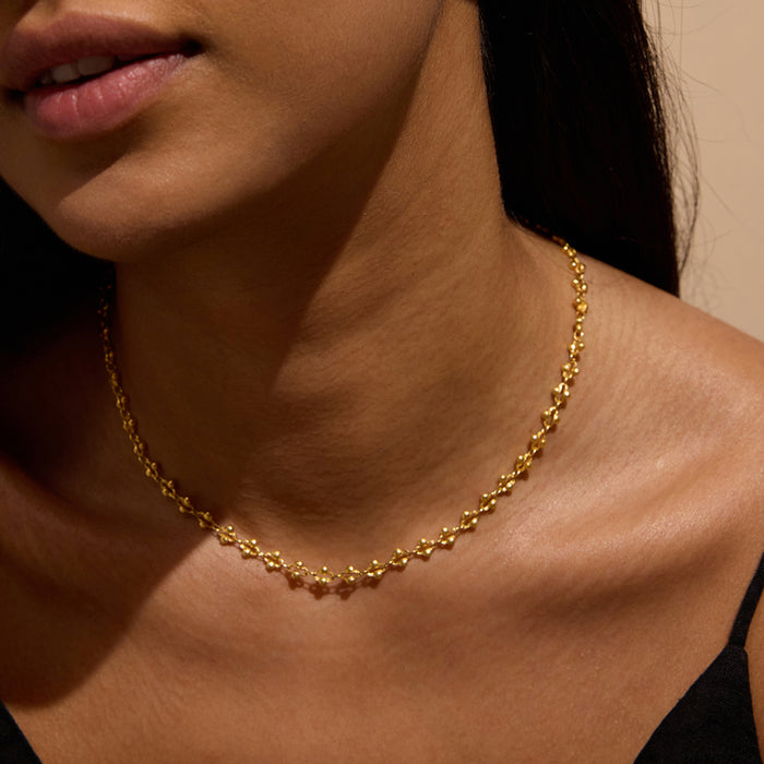 A close-up of a model wearing the Golden Hour Coin Chain Necklace, showcasing its delicate and timeless design. This spiritual jewelry piece is perfect for meditation and serves as a meaningful talisman for protection, embodying the essence of the sun and moon, ideal for yoga and manifestation practices.