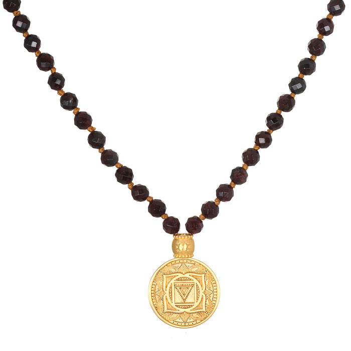 Dark brown faceted beads with gold spacers and a large gold circular pendant featuring an engraved mandala design.