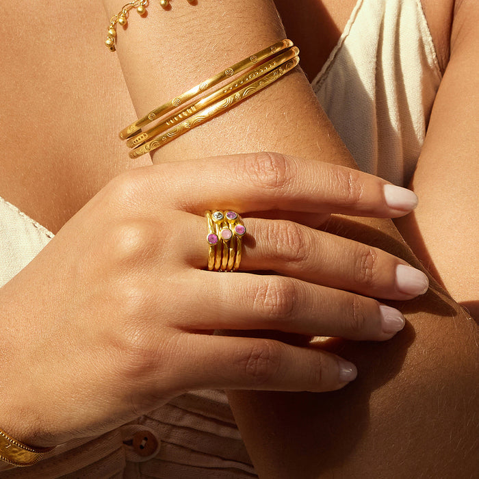 A detailed view of hands adorned with the Guided by Love Gemstone Stacked Ring, showing its shimmering gold and vibrant gemstones. This spiritual jewelry piece is ideal for enhancing meaningful intentions and fostering a connection to the sun and moon, making it a great companion for meditation and self-discovery.