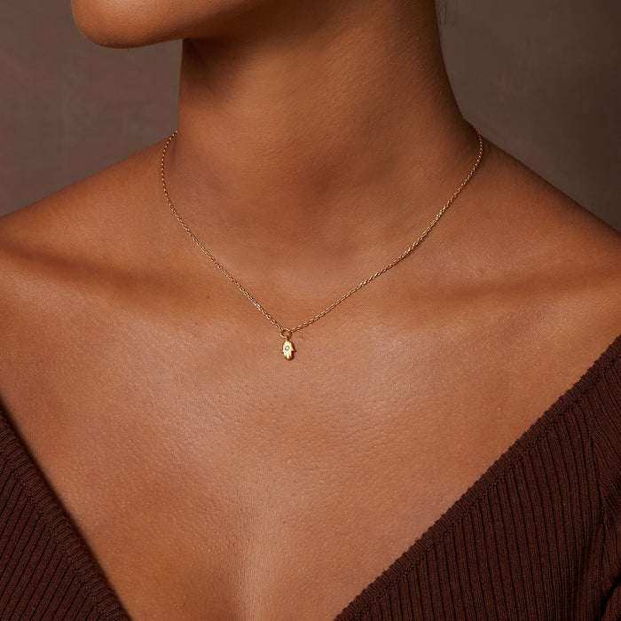 Close-up of a model wearing the Guiding Hand Mini Hamsa Necklace, showcasing the delicate design and labradorite accent. This spiritual jewelry piece is perfect for meditation and brings protection, making it a meaningful charm for enhancing one's spiritual journey.