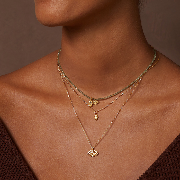 Close-up of the Guiding Hand Mini Hamsa Necklace worn with additional delicate necklaces, embodying themes of spiritual jewelry and charm, perfect for yoga and mediation enthusiasts seeking protection and meaning.