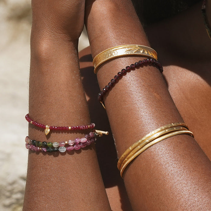 Close-up of the Healing Heart Red Onyx Heart Bracelet paired with other bracelets, highlighting its role as a talisman for peace and spiritual growth in meditation practices.