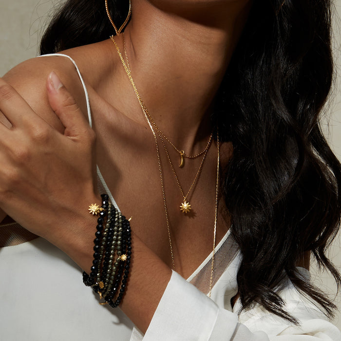 Close-up of the Here Comes the Sun Necklace worn with other gold pieces, illustrating the beauty of spiritual jewelry inspired by the sun and moon. This elegant arrangement is perfect for yoga lovers seeking meaningful treasures that support meditation, talisman, and spiritual practice.