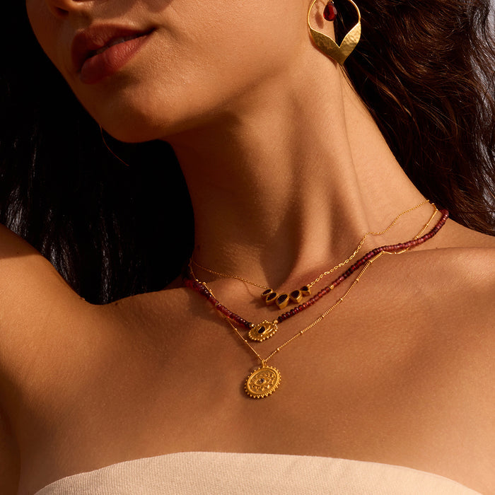 Layered look featuring the Internal Fire Garnet Lotus Beaded Necklace among other spiritual jewelry pieces, emphasizing its role as a protective talisman and meditation aid.