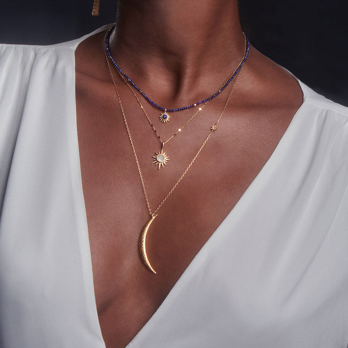 A woman wearing the Illuminated Path Gold Moon Necklace, showcasing its delicate crescent moon pendant and star charm, symbolizing spiritual jewelry and protection. This piece is perfect for meditation and manifestation, enhancing the wearer's yoga practice and connection to the sun and moon.