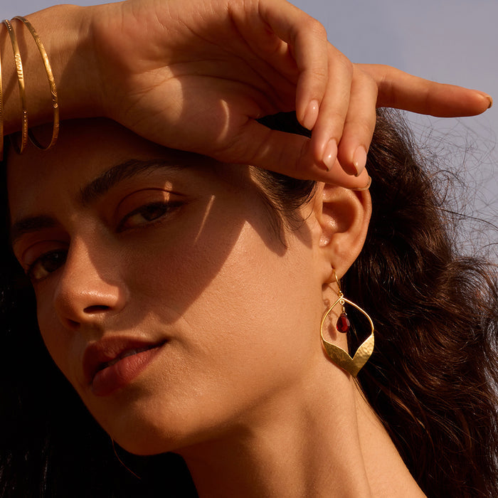 Model wearing Infinite Possibilities Garnet Lotus Earrings, capturing the essence of spiritual, meaningful adornment ideal for yoga, meditation, and as a protective talisman.