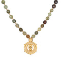 Inhabit Your Power Smokey Quartz Green Garnet Mala featuring 108 smokey quartz and green garnet beads, designed as spiritual jewelry for meditation and as a meaningful talisman. This mala symbolizes protection with its intricate hamsa charm and evil eye made of labradorite, perfect for those practicing yoga and manifestation. Ideal for enhancing spirituality and zodiac connections.