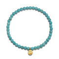 Inner Voice Lotus Gemstone Bracelet featuring turquoise beads and a golden lotus charm, symbolizing new beginnings and health. A perfect piece of spiritual jewelry for meditation, with meaning and charm for manifestation.