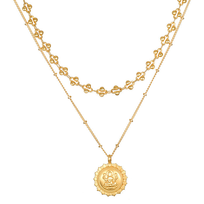 Two-layer gold-toned necklace set with decorative geometric charms on upper chain and circular medallion pendant on lower cha