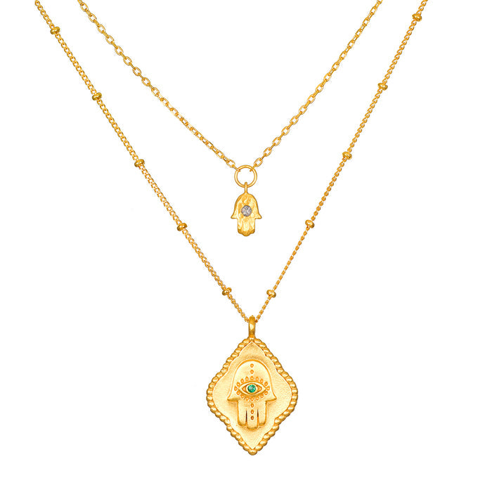 The Intention of Blessings Necklace Set featuring two necklaces in 18kt gold plate, adorned with hamsa symbols for protection and spirituality, ideal for meditation and manifestation. This spiritual jewelry serves as a meaningful talisman, enhancing your yoga practice and daily affirmations.
