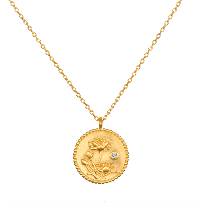 Joyful Beginnings Necklace features an intricate 18kt gold plated pendant adorned with lotus flowers and a white topaz stone, symbolizing new beginnings and individuality, perfect for spiritual jewelry, meditation, and meaningful charm.