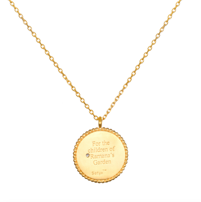 Joyful Beginnings Necklace featuring an 18kt gold plated pendant engraved with the words 'For the children of Ramana's Garden', symbolizing new beginnings and potential. This spiritual jewelry is perfect for meditation and serves as a meaningful talisman, ideal for yoga and manifestation practices. It embodies the essence of protection, charm, and the connection to the sun and moon symbolism.