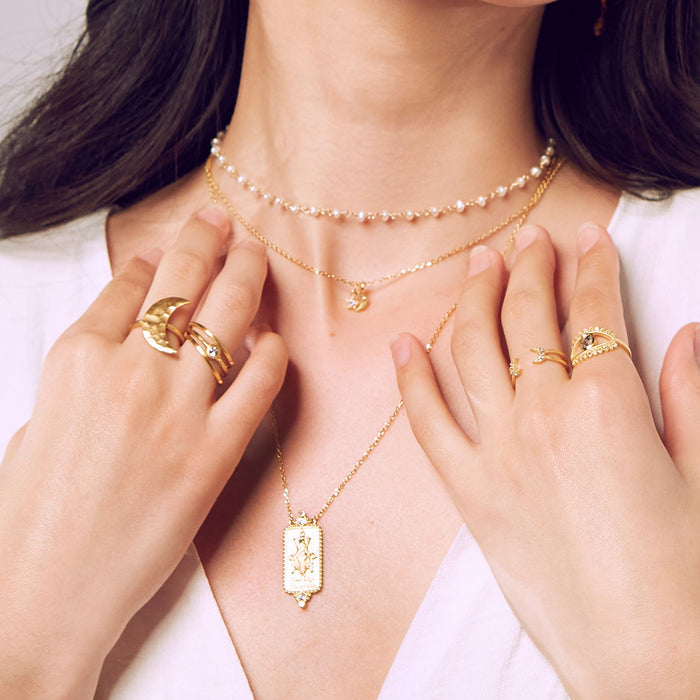 A display of layered jewelry including the Keeper of Positivity Eye Blue Topaz Ring, surrounded by other spiritual jewelry pieces that evoke protection and meaningful energy for meditation enthusiasts.