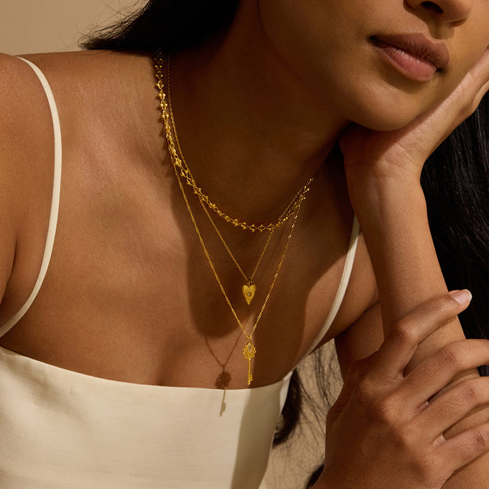 A model wearing the Key to My Heart White Topaz Key Necklace layered with other spiritual jewelry, creating a thoughtful display of personal meaning. This elegant style suits practices like yoga and meditation and enhances your manifestation journey with its cosmic charm, connecting the sun and moon energies.